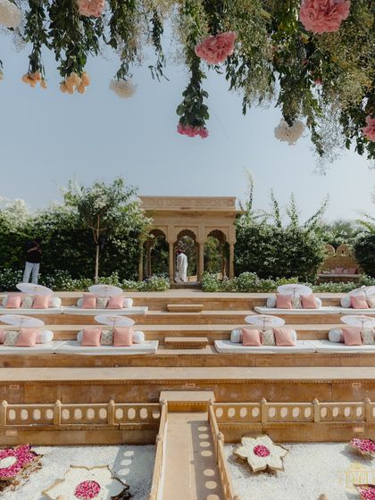 The tiered stone seating of the Suryagarh amphitheater was adorned with soft pink and white cushions for this pastel wedding. The design provided guests with a comfortable and picturesque view of the ceremony, with hanging florals adding to the romantic, garden-like feel.