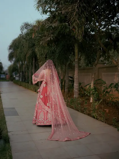An artistic shot of the bride from behind, her long, flowing veil creating a sense of mystery and elegance as she walks.