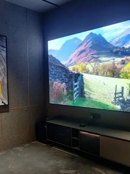 A large, vibrant screen serves as the centerpiece of this modern room. The setup is designed to deliver stunning picture quality for everything from scenic documentaries to fast-paced action films.