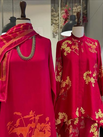 A display of luxurious silk outfits by Avni Bhuva, featuring bold floral prints in vibrant shades of pink and teal.