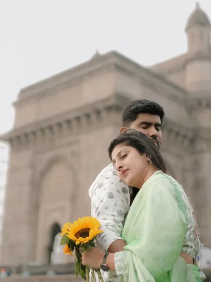 A peaceful and affectionate pose, with her resting on his shoulder, looking out at the view.