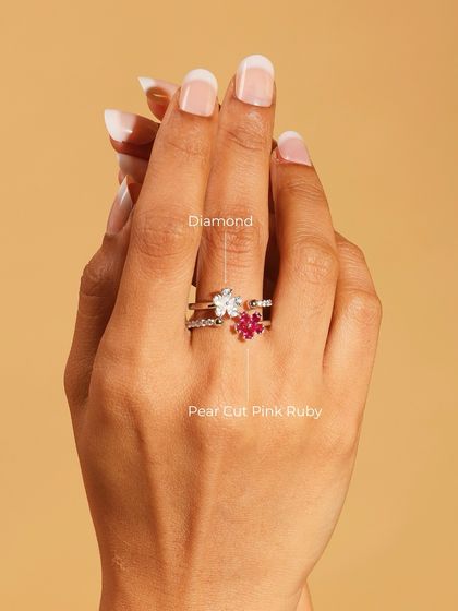 The "Two Flowers Ring" worn on the hand, showing how the pear-cut pink ruby and diamond elements sit beautifully across the finger.