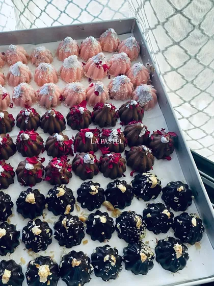 A tray of assorted premium chocolate modaks, showing the different colors and toppings for each unique flavor.