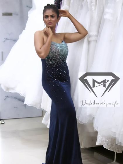 The full silhouette of the navy velvet gown, set against a backdrop of white bridal dresses, creating a beautiful contrast.