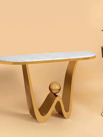 This console table features a playful, modern wave design in its stainless steel base, complete with a balancing sphere accent. The sleek marble top provides a clean surface, making it an eye-catching piece for a hallway or living room.