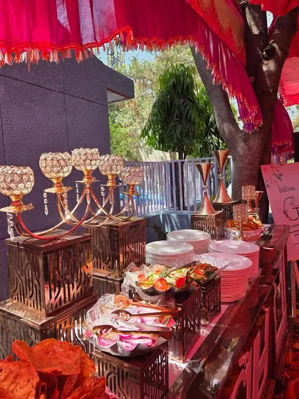 A close-up of our starter and salad station. The setup features ornate crystal candelabras, rustic wooden stands, and a variety of fresh salads and snacks, showcasing our attention to decorative detail.
