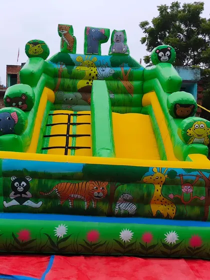 A classic jungle animal themed bouncy castle. The artwork features tigers, giraffes, and monkeys, and the structure includes a dual slide and climbing area.