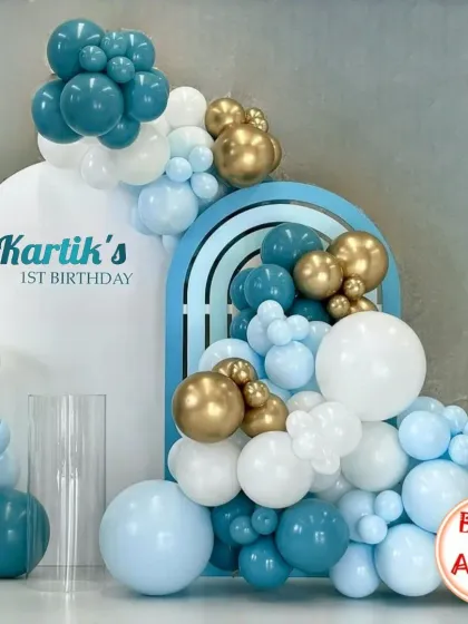 The combination of teal, light blue, white, and gold creates a sophisticated and calming palette for a first birthday.