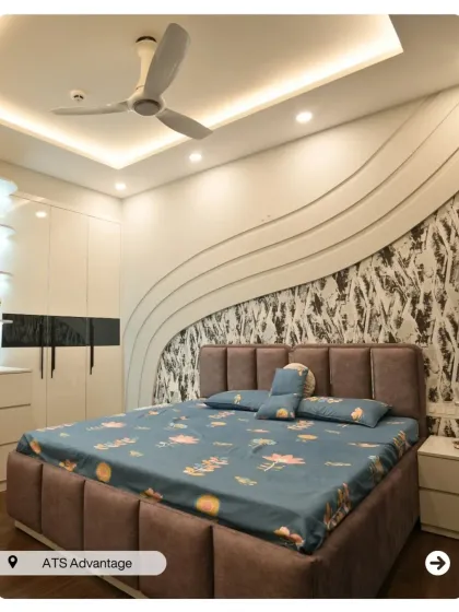 A bedroom with a unique, flowing 3D wall panel behind the bed. The glossy white wardrobes with integrated handles add to the sleek, contemporary feel.