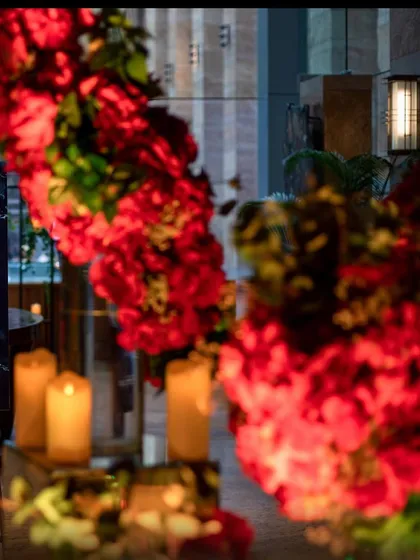 A close-up of the welcome signage and rich red floral decor for a Sangeet ceremony, setting a luxurious tone for the evening.