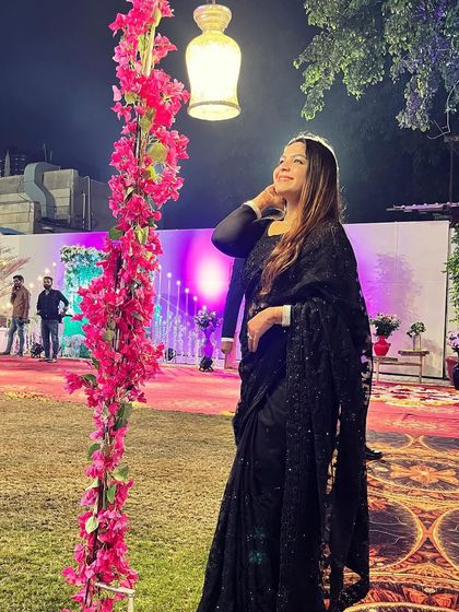 Draped in an elegant black net saree for a wedding reception. A classic black saree with subtle sequin work is a timeless choice that always looks graceful and sophisticated.