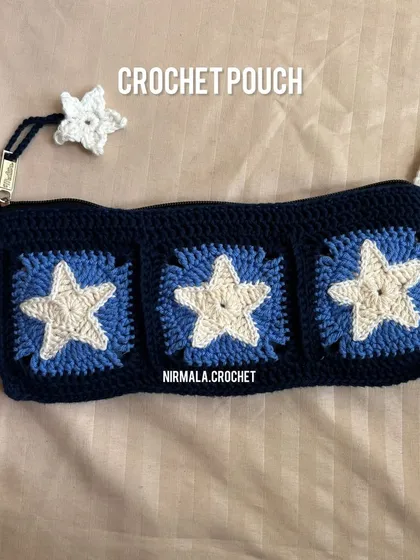 A detailed shot of our star-themed crochet pouch. The design includes a matching star charm, making it a coordinated and stylish accessory for any use.