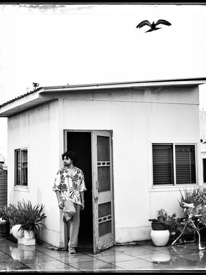Saransh on a rooftop, with a bird flying overhead. This shot feels so serendipitous and free, a perfect moment in time.