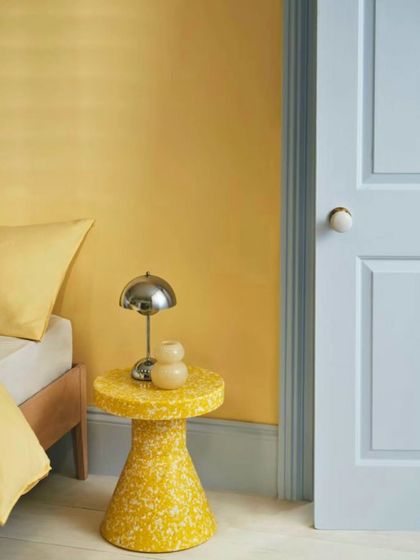 Butter Yellow pairs beautifully with other colors. In this bedroom, a soft yellow wall is complemented by a pale blue door, creating a fresh and playful color combination that feels both modern and classic.