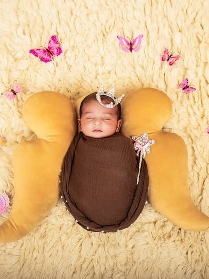 Adding a sprinkle of magic with butterfly props. This whimsical addition transforms the 'little angel' newborn setup into a fairytale scene.