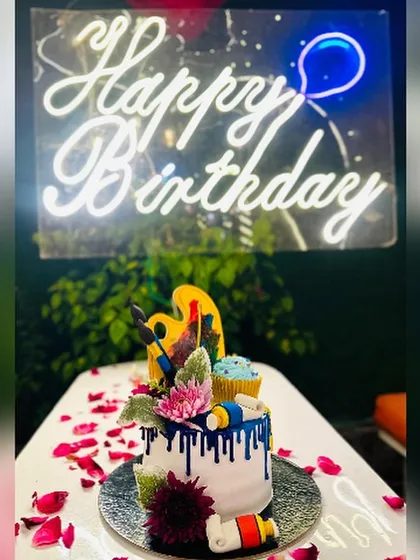 Unleash your inner artist with this creative, art-themed cake. It's adorned with an edible painter's palette, brushes, and tubes of paint, all set against a vibrant blue drip effect.