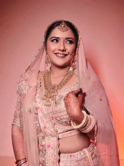A radiant smile from the bride. The soft pink tones in her makeup and outfit create a harmonious and beautiful look.