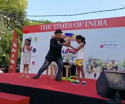 We plan and execute engaging public and corporate events. This outdoor stage for a Times of India event included coordinating live entertainment, like this magician, to captivate the audience.