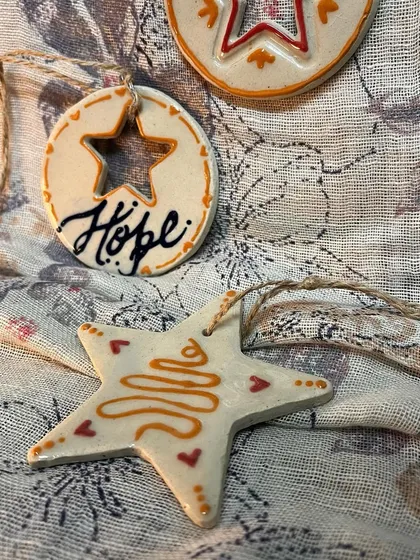 A close-up of the 'Hope' and star ornaments from the set of three.