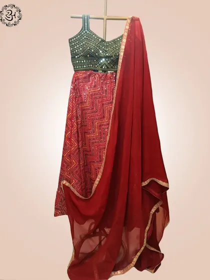 A product shot showing the red lehenga set with its matching deep red dupatta. The gold border on the dupatta ties the whole ensemble together.
