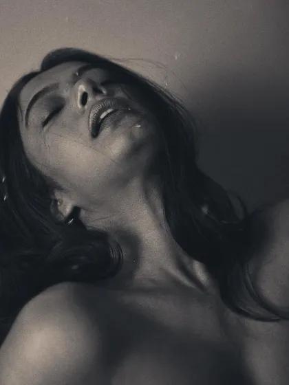 An intimate and sensual monochrome portrait. The focus is on the texture of the skin and the peaceful, dreamlike expression.