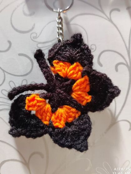 Elegant black butterfly keychains with pops of color like orange, blue, pink, purple, and yellow on the wings.