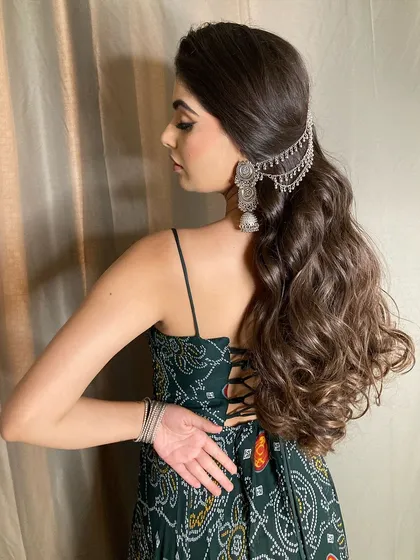 The back profile of this desi look, showing off the beautiful wavy ponytail with a silver hair accessory. It's a great hairstyle for keeping hair managed while still looking festive.