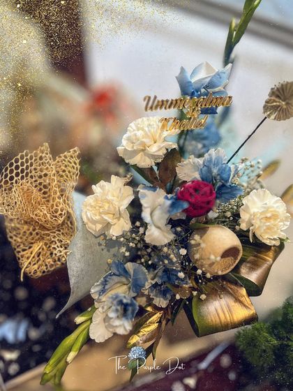 This 'ZarGul' hamper in blue and white tones features a custom name tag and a delicate arrangement of carnations and baby's breath. It’s a perfect example of how the collection can be adapted to different color palettes while maintaining its signature grace.