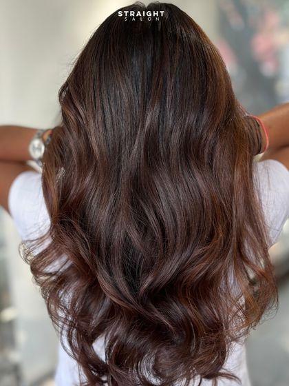 A rich chocolate brunette with subtle dimension and soft waves for a timeless and elegant look.