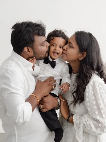 There is nothing more heartwarming than capturing the pure love of a new family. The kisses and cuddles in this portrait show the incredible bond that anchors a family from the very beginning.