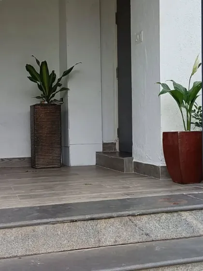 Adding a couple of well-chosen plants can completely change the feel of an entrance. Here, I used two different styles of planters, a tall textured one and a rustic red one, to add a welcoming touch of green.