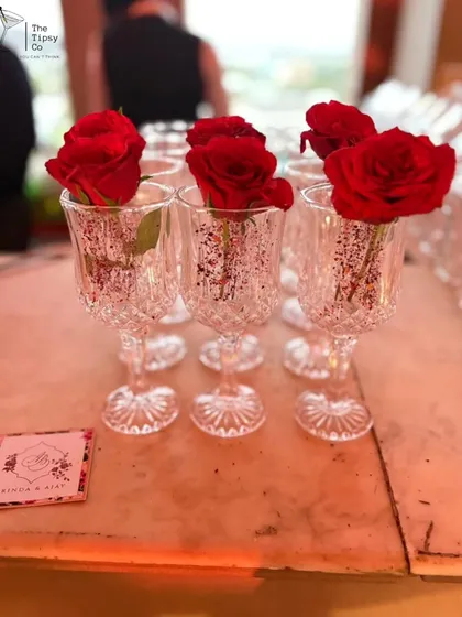 Simple, yet beautiful. These crystal-cut glasses are prepared with a single red rose, adding a touch of romance and elegance to the bar setup before the drinks are even poured.