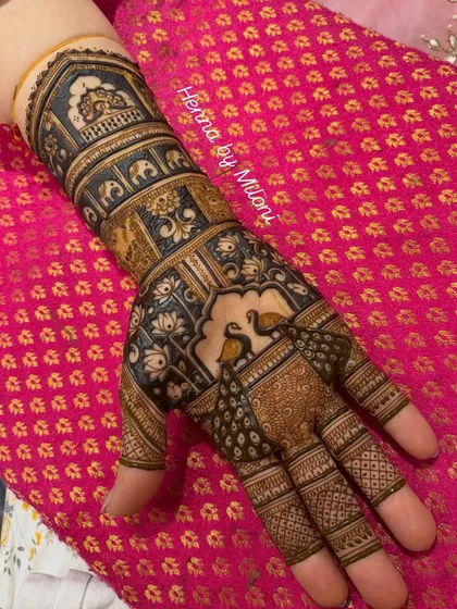 This elegant design was for the bride's mom. It features beautiful peacocks perched in a jharokha, surrounded by lotus and elephant patterns, fit for royalty.