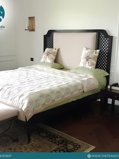 This elegant bed design features a tall headboard with an upholstered center panel and intricate wooden lattice work on the sides, blending traditional craftsmanship with modern comfort.