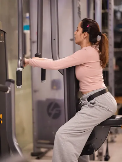 The pec deck machine is excellent for isolating the chest muscles. Here, a member works on her pectoral strength and definition.