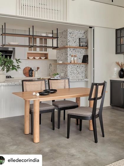 A feature from Elle Decor showing the Zen House dining area. The open kitchen, terrazzo pillar, and oak dining table create a space that is both airy and grounded.
