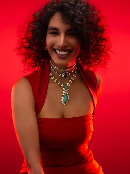 Mastering color and light is fundamental. Here, a bold red background makes the subject and her exquisite jewelry come alive. We practice using color theory and precise lighting to create vibrant, impactful portraits that command attention.