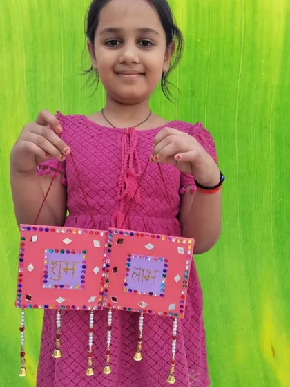 This young artist proudly holds up her handmade "Shubh Labh" wall hanging. Our Diwali craft sessions are a great way for kids to create beautiful decorations for their homes.