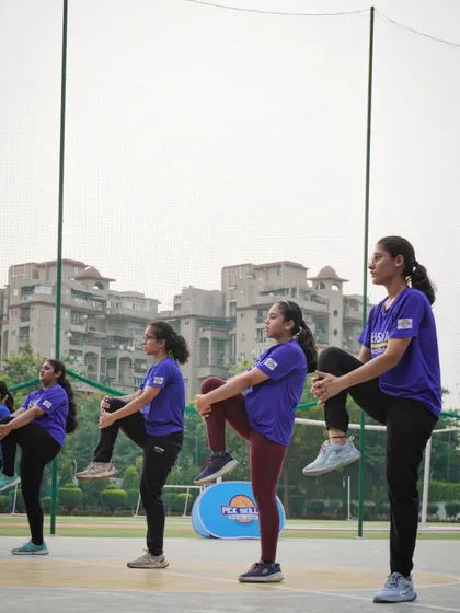 A group of our female athletes performing dynamic stretches during a warm-up. Flexibility and proper preparation are key components of our training, helping to maximize performance and prevent injuries.