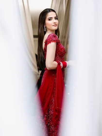 A moment of quiet grace before the ceremony. This look was all about soft glamour to complement her intricate red gown, ensuring she looked and felt like a dream.