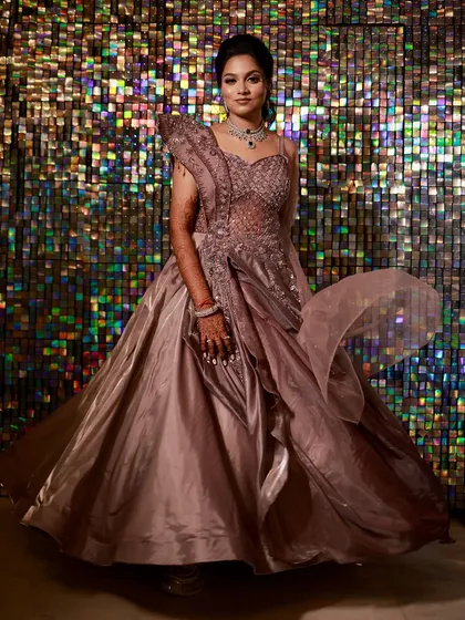 For the bride who wants to make a grand entrance at her sangeet. This full-length shot shows a dramatic, flowing gown with intricate beadwork, paired with an elegant updo and sparkling diamond jewellery.