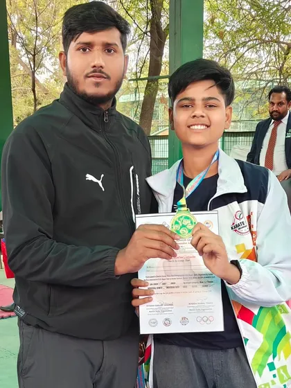 A junior champion beaming with joy after winning his medal at the district karate championship.