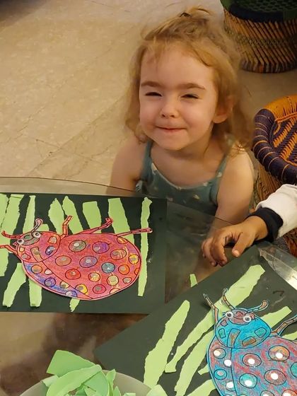 The happy faces say it all! These toddlers are so proud of their ladybug art, a mixed-media project combining drawing, coloring, and collage.