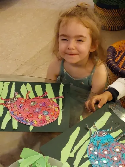 The happy faces say it all! These toddlers are so proud of their ladybug art, a mixed-media project combining drawing, coloring, and collage.