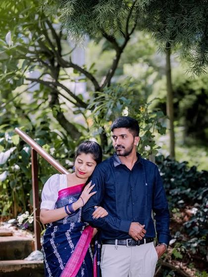 A candid-style shot of a couple walking down a garden staircase.