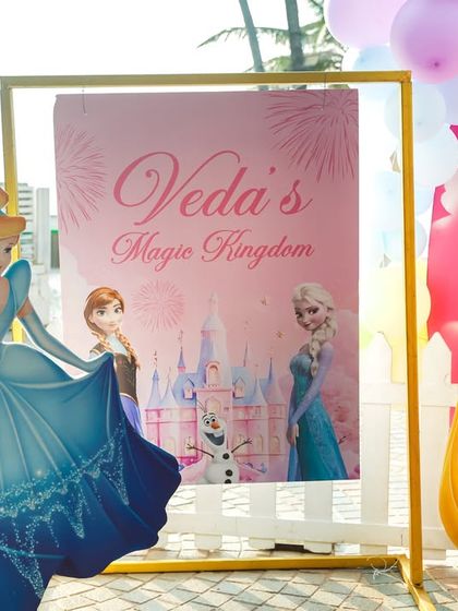 A personalized welcome sign for "Veda's Magic Kingdom," flanked by cutouts of Cinderella and Rapunzel.