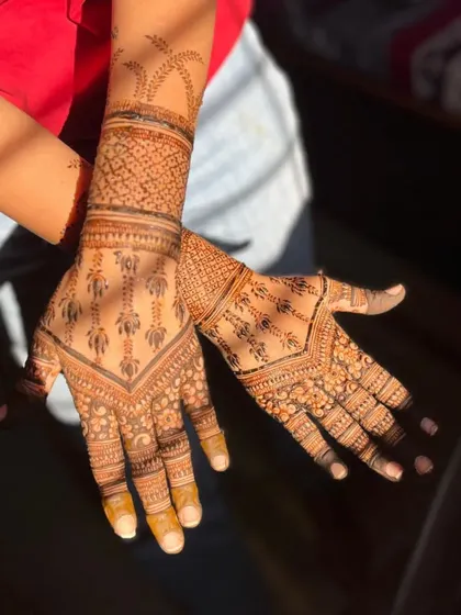 The sunlight highlights the beautiful color of this Indo-Arabic mehendi, which features lotus motifs and a patterned cuff.