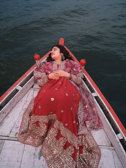 Draped in tradition, floating on history. This high-angle shot captures a moment of complete surrender to the calm of the Ganga, with the rich red attire creating a beautiful contrast.