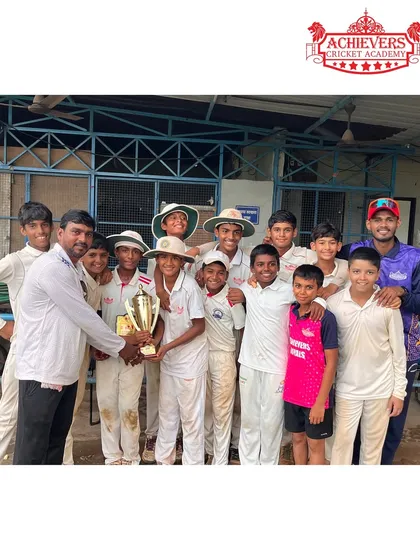 A coach and players holding the AT Cup U-14 trophy. These are the moments that make all the hard work worthwhile.