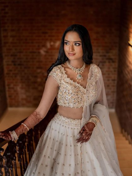 A close-up on her face and torso, showing the intricate details of her blouse and her flawless makeup.